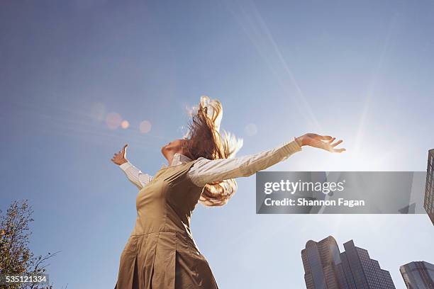 woman jumping for joy - arms outstretched foto e immagini stock