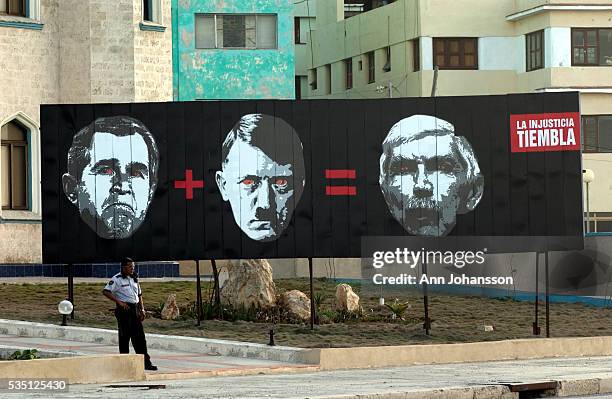 Billboard saying that a face of George W. Bush plus a face of Adolf Hitler equals a face of Luis Posada Carriles stands near the U.S. Interest...