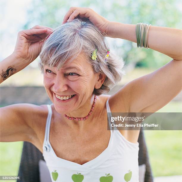 senior woman adjusting hair clips - old woman tattoos stock pictures, royalty-free photos & images
