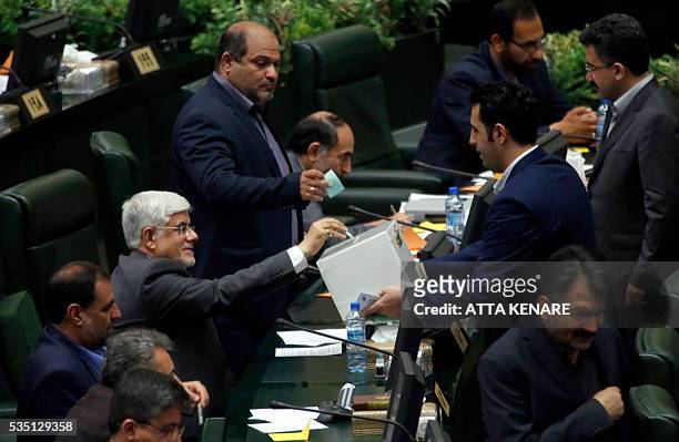 Iranian leading reformist MP, Mohammad Reza Aref casts his vote for the new Parliament speaker, during a parliament session in Tehran on May 29,...
