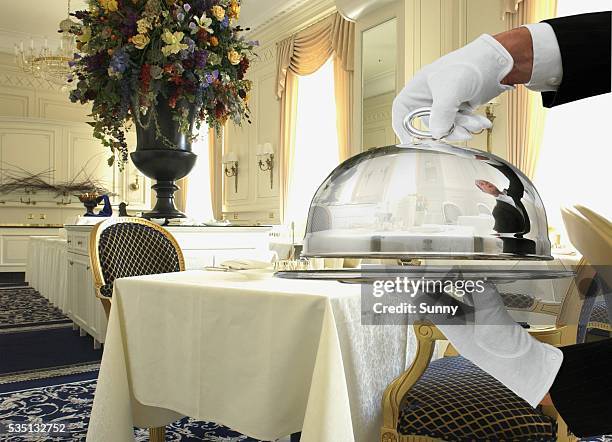 waiter carrying serving tray - zilverkleurige handschoen stockfoto's en -beelden