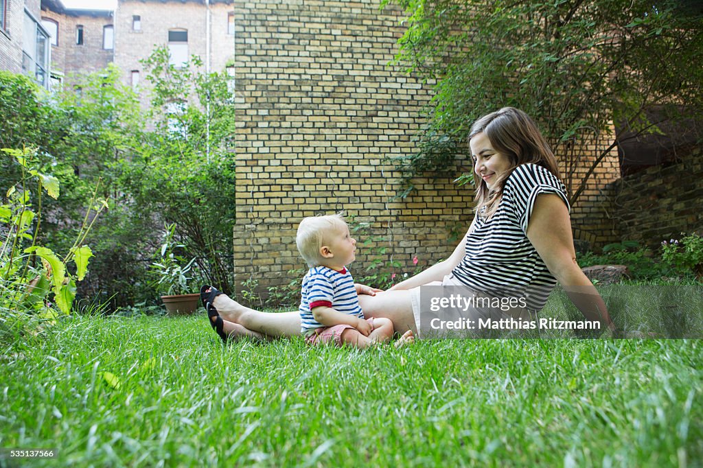Young mother with toddler (6-11 months) relaxing on grass