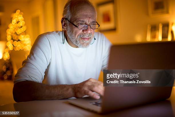 senior man using a laptop - old spectacles stock pictures, royalty-free photos & images