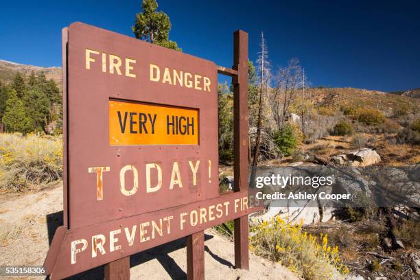 a fire danger sign next to forest that has been burnt by a fire in the tule river - california wildfires stock pictures, royalty-free photos & images