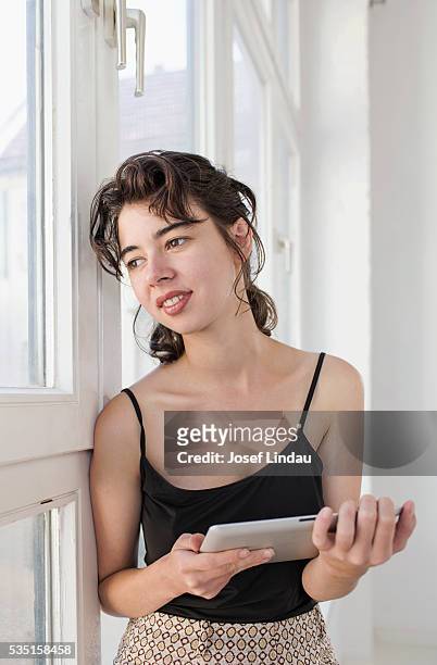 woman looking out of window - josef lindau stock-fotos und bilder