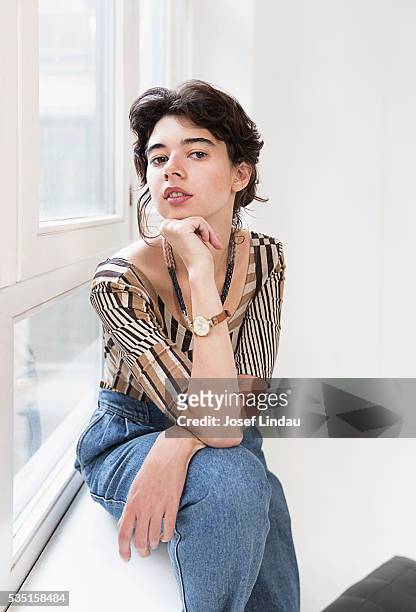 confident woman sitting at windowsill - josef lindau stock-fotos und bilder