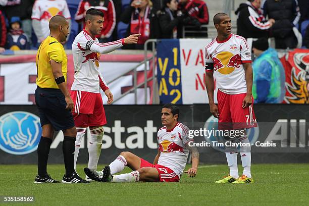 Tim Cahill, , New York Red Bulls, injured as team mates Armando, , and Roy Miller, summon the trainer. Cahill left the match in the 27th minute...