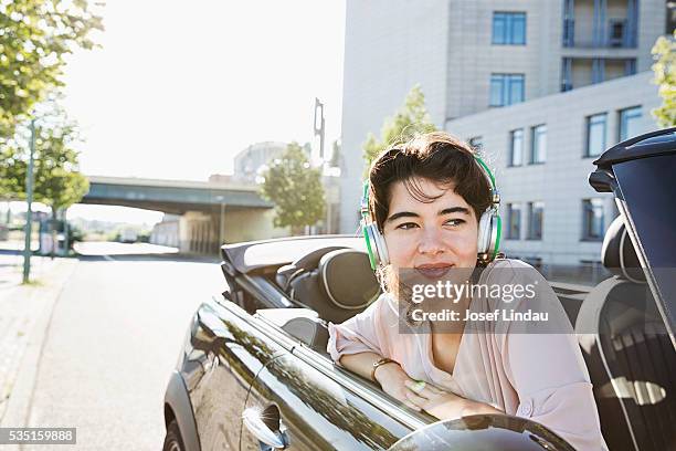 young woman sitting in her car - josef lindau stock-fotos und bilder