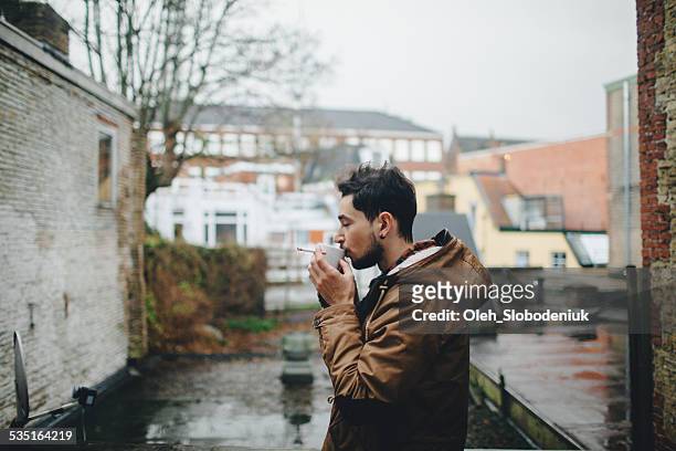 man smoking and drinking coffee - amsterdam cityscape stock pictures, royalty-free photos & images