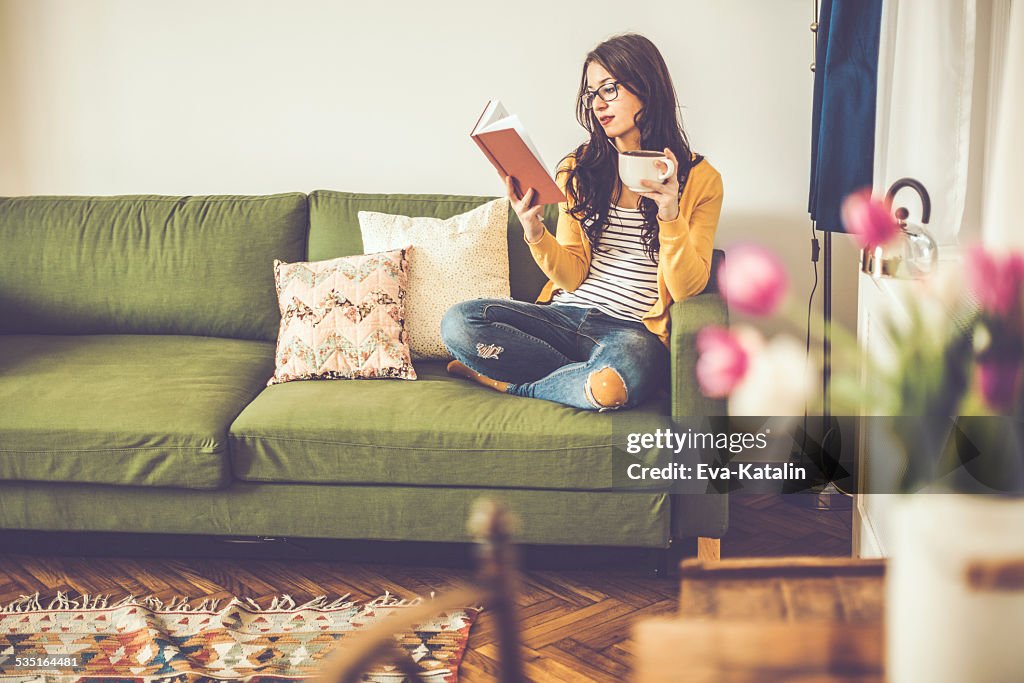 Junge Frau liest ein Buch wie zu Hause fühlen