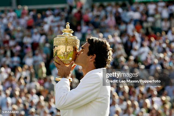 Swiss professional tennis player Roger Federer kisses the Gentlemen's Singles Trophy after beating Rafael Nadal of Spain 7-6, 4-6, 7-6, 2-6, 6-2 to...