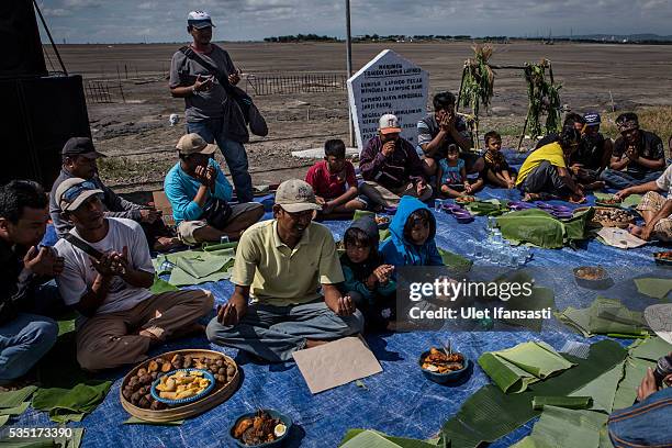 Residents of villages pray together at mudflow during the tenth anniversary of the mudflow eruption on May 29, 2016 in Sidoarjo, East Java,...