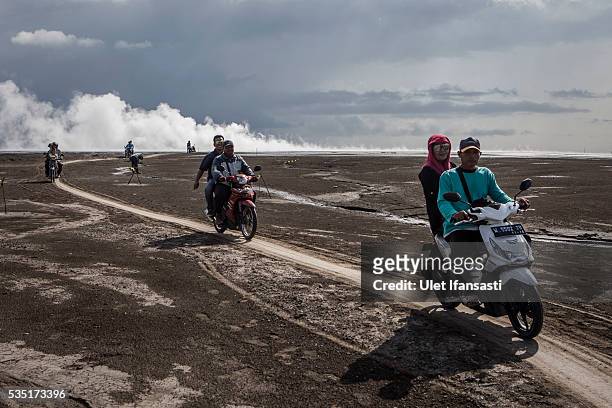 Visitors ride motorcycles after watching smoke coming out from the mudflow during the tenth anniversary of the mudflow eruption on May 29, 2016 in...