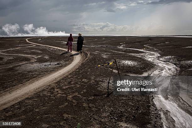 Visitors watch smoke coming out from the mudflow during the tenth anniversary of the mudflow eruption on May 29, 2016 in Sidoarjo, East Java,...
