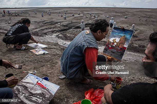 Artists take action to paint together at mudflow during the tenth anniversary of the mudflow eruption on May 29, 2016 in Sidoarjo, East Java,...