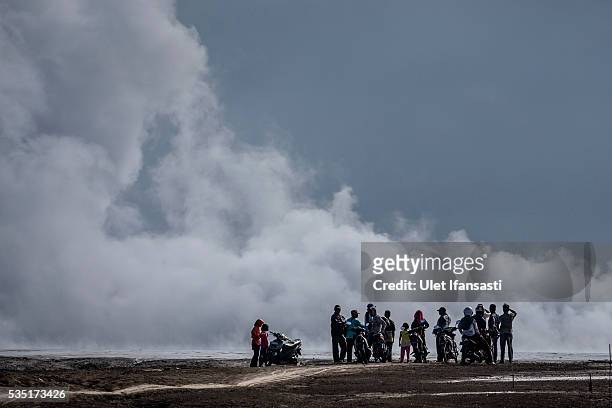 Visitors watch smoke emerge from the mudflow during the tenth anniversary of the mudflow eruption on May 29, 2016 in Sidoarjo, East Java, Indonesia....
