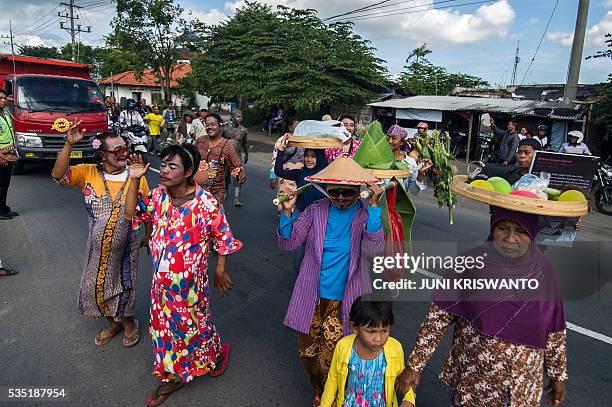 Survivors dressed as women, to show their support for the women who lost their livelihoods, take part in a parade to mark the 10th anniversary of the...