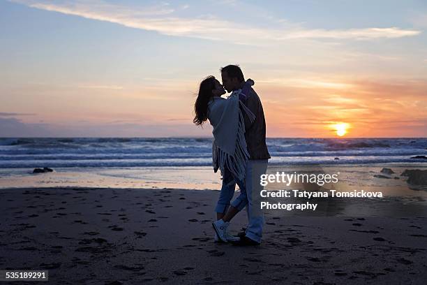 young couple in love on the ocean on sunset - croyde imagens e fotografias de stock