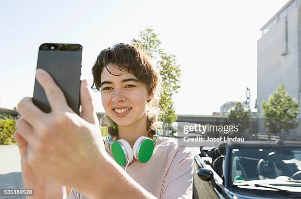 smiling woman taking selfie - josef lindau stock-fotos und bilder