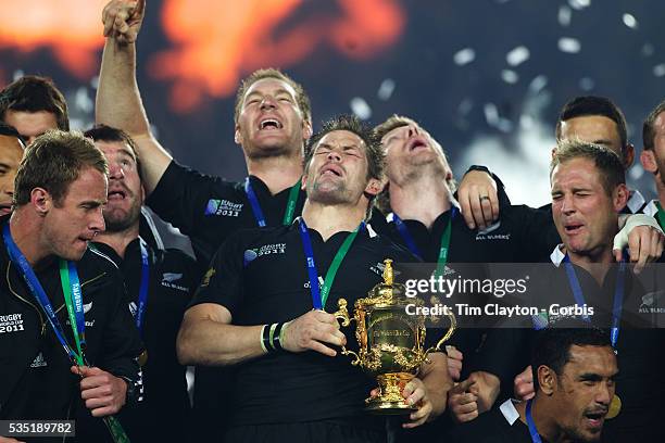 New Zealand Captain Richie McCaw lifts the trophy as his team mates celebrate after New Zealand's 8-7 victory over France in the Final of the IRB...