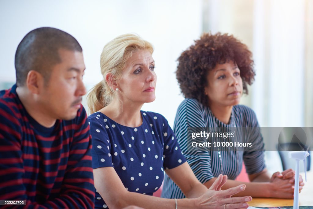 Coworkers discussing project in conference room