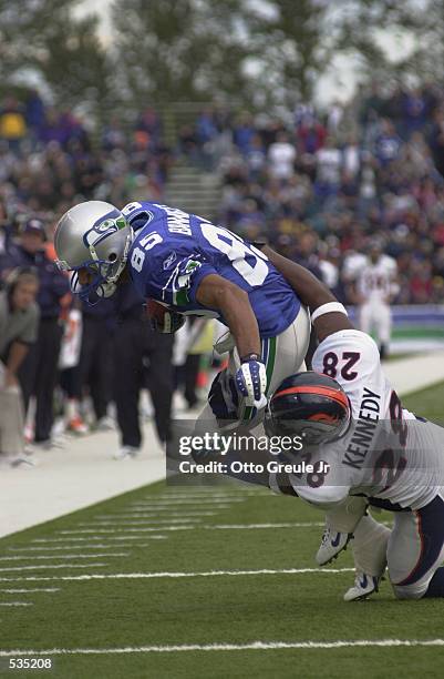 Alex Bannister of the Seattle Seahawks is brought down by Kenoy Kennedy of the Denver Broncos during the game at Husky Stadium in Seattle,...