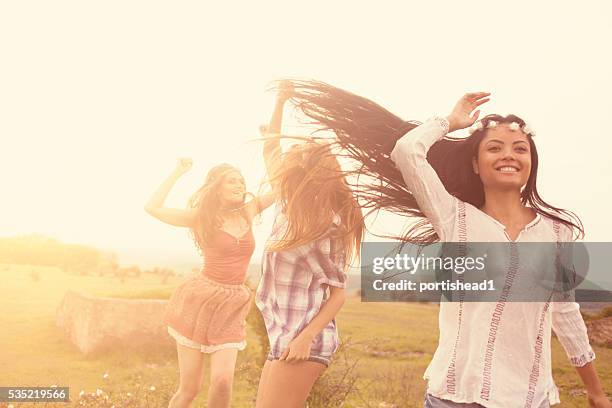 beautiful smiling young hipster women dancing in the grassland - gypsy of the year competition stockfoto's en -beelden