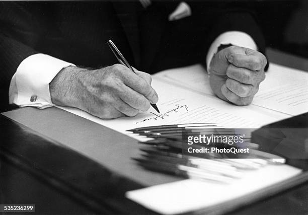 Closeup of Lyndon Johnson's hands, as he signs an Executive Order, Washington DC, 1968.