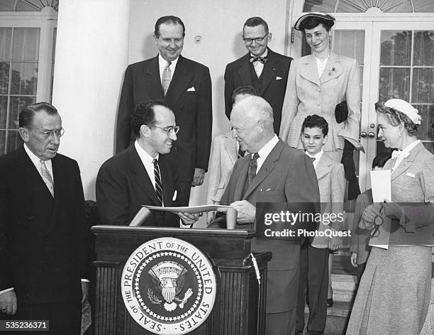 Dr Jonas Salk, University of Pittsburgh scientist who discovered the anti-polio vaccine, receives a special citation from President Eisenhower at the...