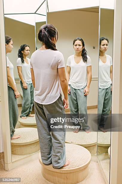 teenage girl reflecting in front of mirror - girl changing room shop stock-fotos und bilder