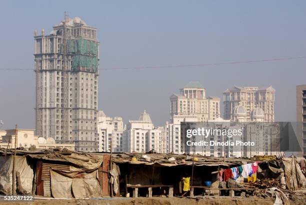 towers at hiranandani complex with worker's cottages in powai, mumbai, maharashtra, india. - slum stock pictures, royalty-free photos & images