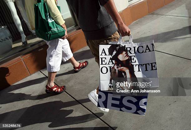 Tina Wolfe and son Clay walk on Wilshire Boulevard after shopping at American Eagle Outfitters in Santa Monica, in Los Angeles.