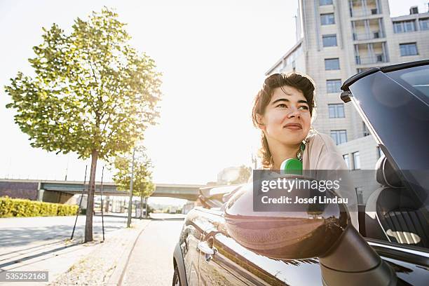 young woman looking out of open top sports car - josef lindau stock-fotos und bilder