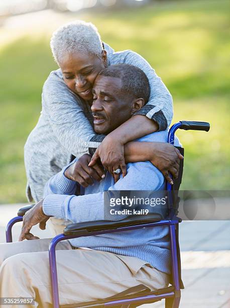 senior pareja afroamericana, hombre en silla de ruedas - african american man helping elderly fotografías e imágenes de stock
