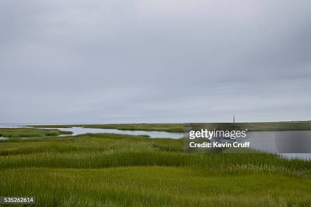 sailboat anchored in salt marshes on cape cod by kevin cruff - north atlantic ocean stock pictures, royalty-free photos & images