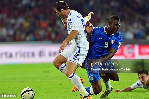 Italy's forward Mario Balotelli vies with Armenia's Varazdat Haroyan and Robert Arzumayan during the FIFA 2014 World Cup Qualifier football match...