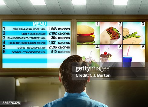 Man Rates Fast Food Man Reading Fast Food Menu With Calorie Chart High-Res Stock Photo ...