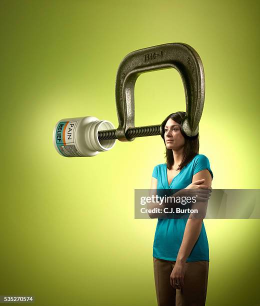 woman with "pain relief" vice on head - headache stock pictures, royalty-free photos & images