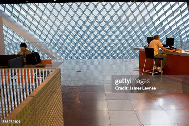 Two men work at computers in The Seattle Central Library. It was designed by the Dutch Architect Rem Koolhaas, and is the flagship library of the...