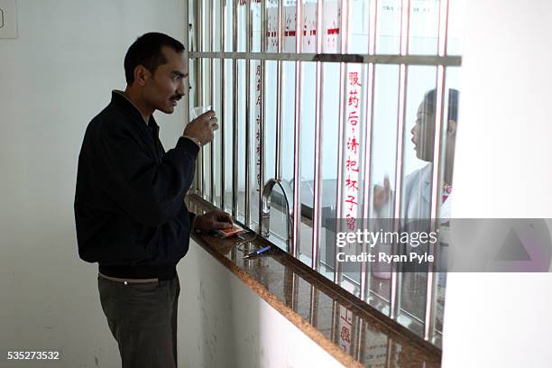 Inside the Yuandong Hospital, in central Kashgar, Alimjan takes his methadone treatment. In Kashgar AIDS is has erupted as one of the foremost...