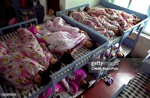 Zhang MengHan and other children prepare for their afternoon sleep on bunk beds at the Li Xiaoshuang Gymnastics School in Xiantao, China. Li...