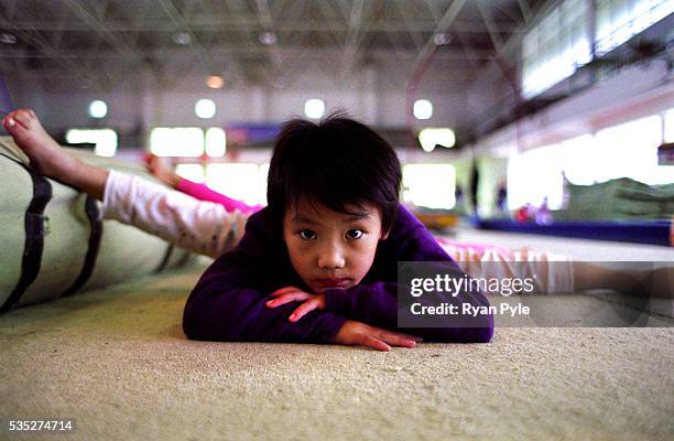 Zhang MengHan, 6 and a half years old, stretches at the Li Xiaoshuang Gymnastics School in Xiantao, China. Li Xiaoshuang was a sucessful Chinese...