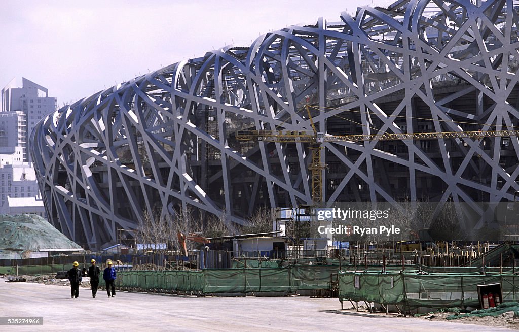 China - Beijing - Olympic Sites - Workers Walk Past Olympic Stadium