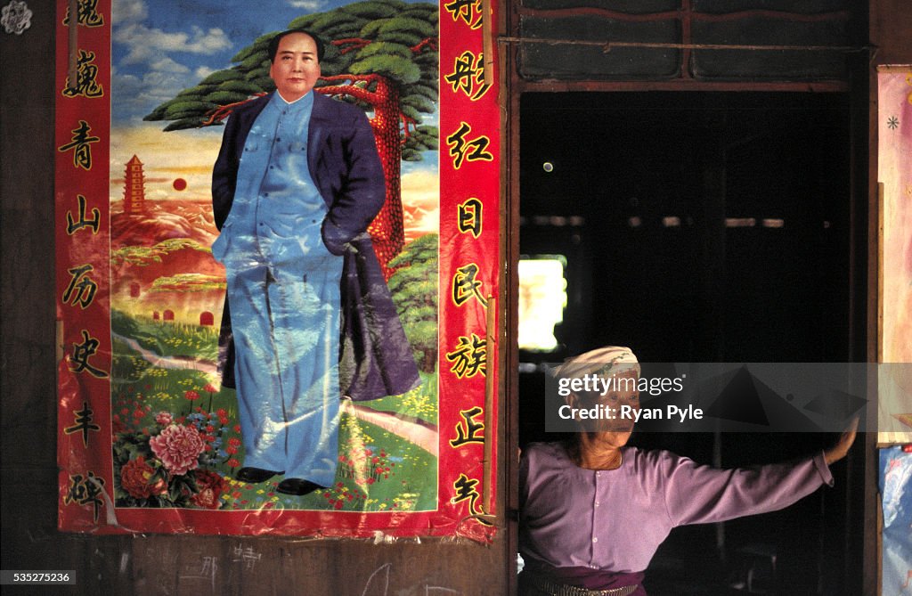 China - Yunnan - Xishuangbanna - A Woman Stands Beside a Chairman Mao Poster