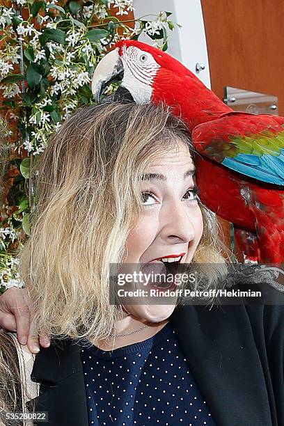 Actress Marilou Berry poses with parrot Arthur during Day Height of the 2016 French Tennis Open at Roland Garros on May 29, 2016 in Paris, France.