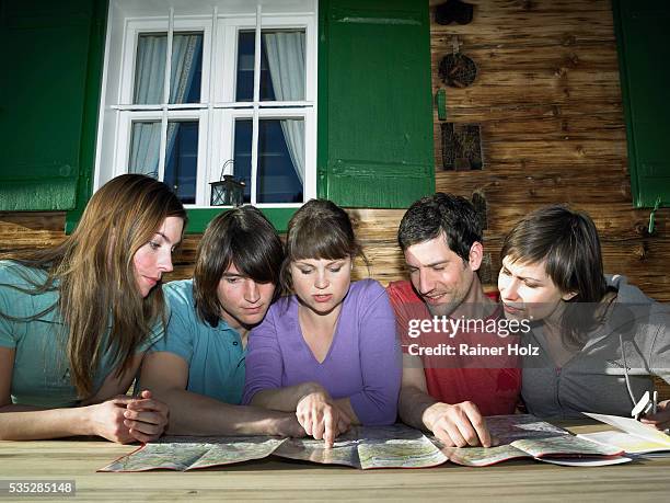 group of five young people looking together at map - orientierungslauf landkarte gruppe stock-fotos und bilder