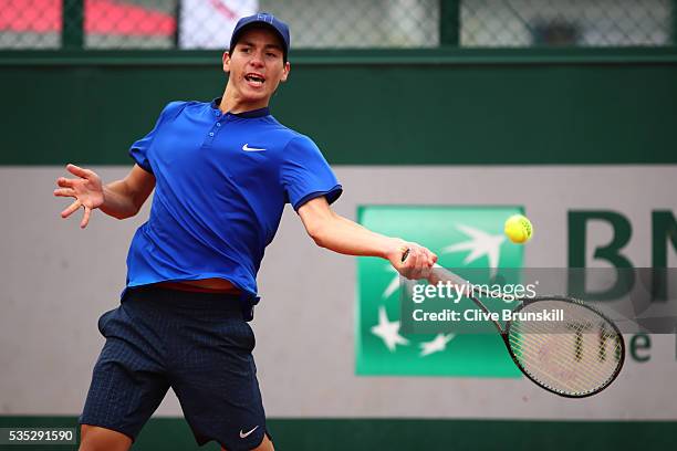 Yshai Oliel of Israel hits a backhand during the Boys Singles first round match against Kenneth Raisma of Estonia on day eight of the 2016 French...