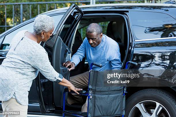 minusválidos hombre mayor llegar en automóvil para silla de ruedas - african american man helping elderly fotografías e imágenes de stock