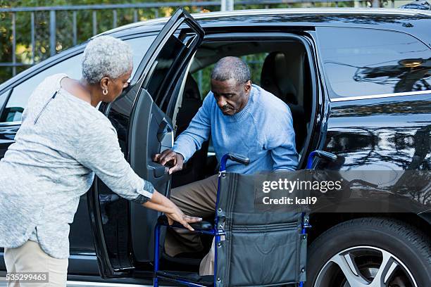disabled senior man getting from car to wheelchair - black couple in car serious stock pictures, royalty-free photos & images