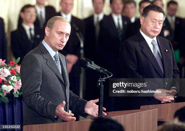 Russian President Vladimir Putin speaks to reporters as Japanese Prime Minister Yoshiro Mori listens during their joint press conference.